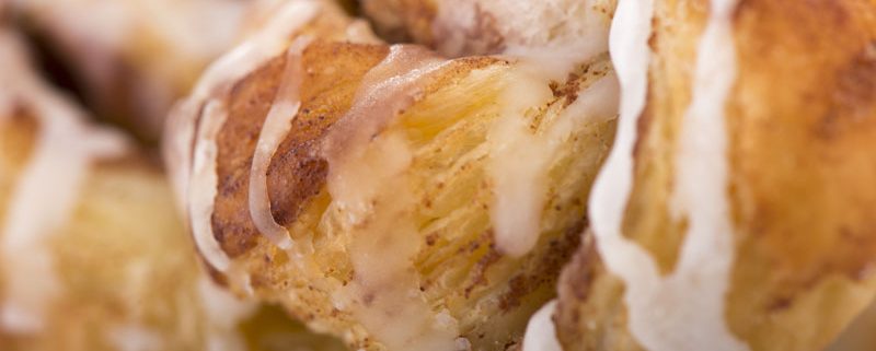 Close-up on sweet bread with specks of cinnamon and covered with icing