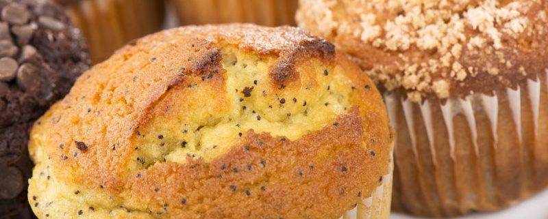 Tasty Pastry Muffins: Close up on lemon poppyseed muffin with other types of muffins in background