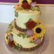 Tasty Pastry Custom Cakes: Two-tier sunflower wedding cake or birthday cake with light green icing & a variety of iced edible flowers